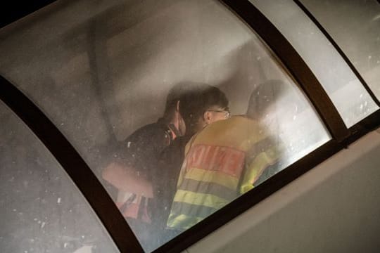 Polizeibeamte begleiten einen Mann auf dem Flughafen Leipzig-Halle in ein Charterflugzeug.