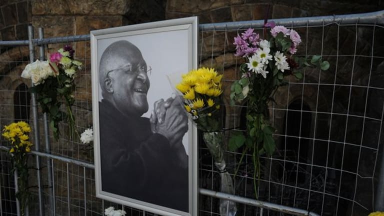 Blumen und ein Foto von Desmond Tutu an einem Gerüst in der St.