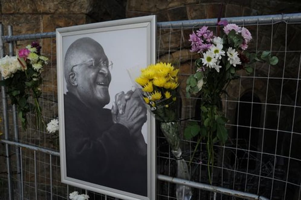 Blumen und ein Foto von Desmond Tutu an einem Gerüst in der St.
