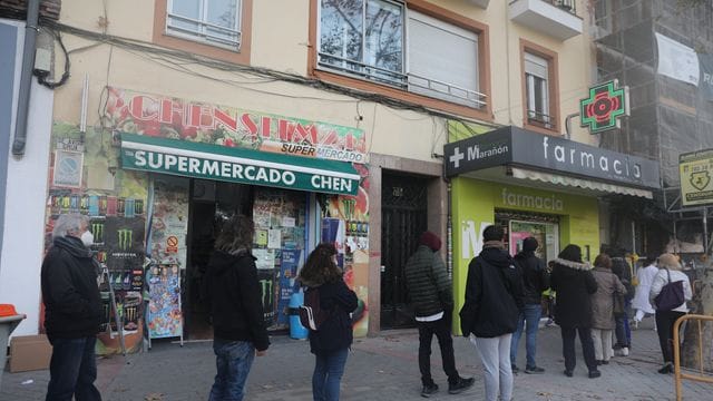 Menschen stehen vor einer Apotheke in Madrid an, um einen Schnelltest zu kaufen.