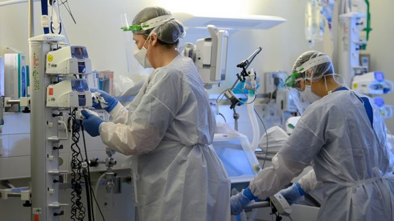 Pflegerinnen in Schutzkleidung auf der Covid-19-Intensivstation einer Klinik.