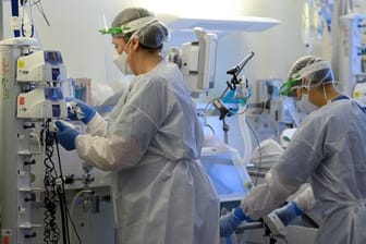 Pflegerinnen in Schutzkleidung auf der Covid-19-Intensivstation einer Klinik.