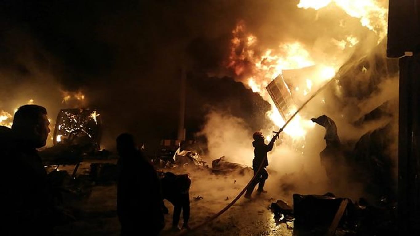 Flammen steigen aus den Containern in Latakia: Feuerwehrleute versuchen, das Feuer zu löschen.