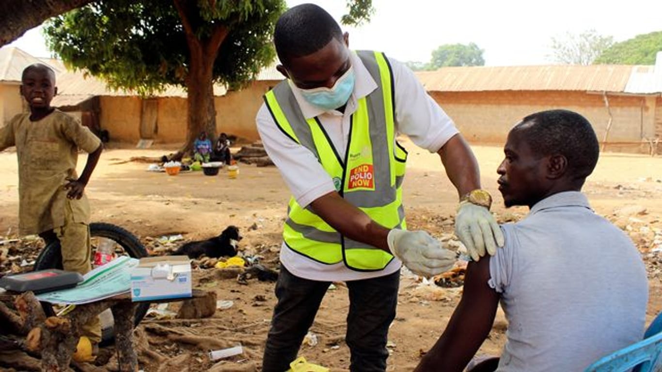 Ein kommunaler Gesundheitshelfer verabreicht einem Mann in Nigeria den Corona-Impfstoff.