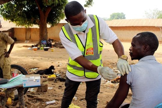 Ein kommunaler Gesundheitshelfer verabreicht einem Mann in Nigeria den Corona-Impfstoff.