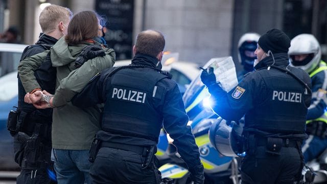 Polizisten in Frankfurt am Main nehmen eine Teilnehmerin einer Corona-Demonstration fest.