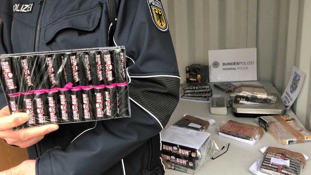 Ein Bundespolizist zeigt beschlagnahmte Böller.