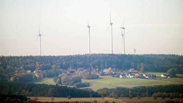 Windräder stehen in einem Wald in Bayern.