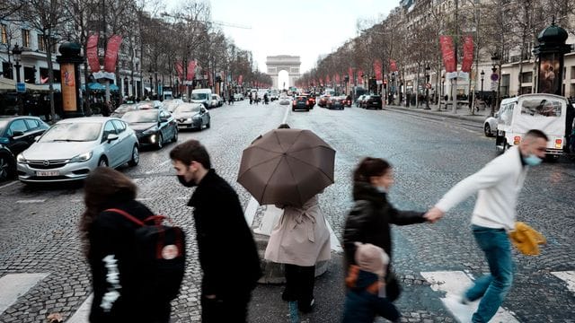 Menschen überqueren die Avenue des Champs-Élysées in Paris. Menschen überqueren die Avenue des Champs-Élysées in Paris.