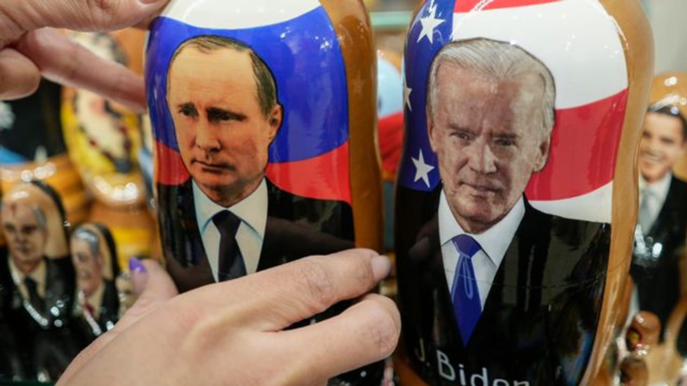 Auf traditionellen russischen Holzpuppen (Matrjoschkas) sind Russlands Präsident Wladimir Putin (l) und US-Präsident Joe Biden zu sehen.