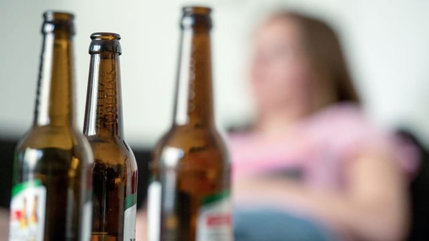 "Der Suchtkranke kreist nur um sich selbst und hat die Kinder nicht im Blick": Eine Frau hinter leeren Bierflaschen.