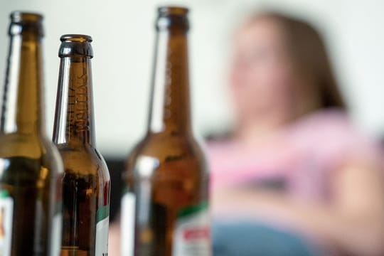 "Der Suchtkranke kreist nur um sich selbst und hat die Kinder nicht im Blick": Eine Frau hinter leeren Bierflaschen.