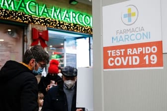 Menschen in Rom warten vor einer Apotheke auf einen Corona-Test.