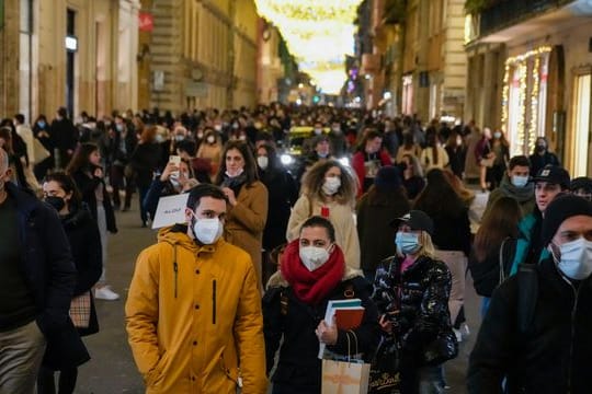 Menschen gehen durch eine Einkaufsstraße in Rom.