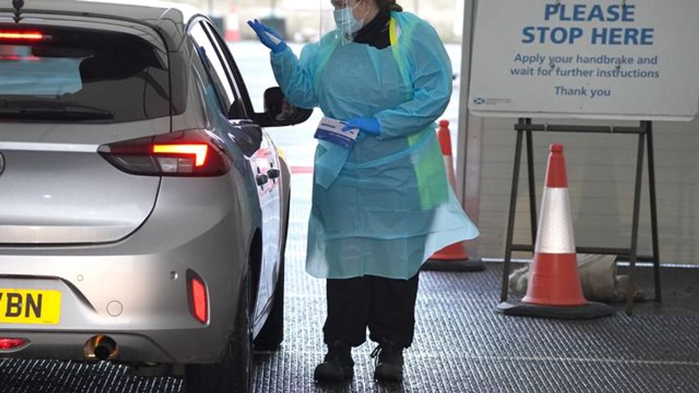 Eine Medizinerin entnimmt einem Bürger eine Probe auf dem Corona-Testgelände am Flughafen Edinburgh.