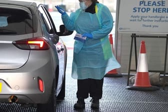 Eine Medizinerin entnimmt einem Bürger eine Probe auf dem Corona-Testgelände am Flughafen Edinburgh.