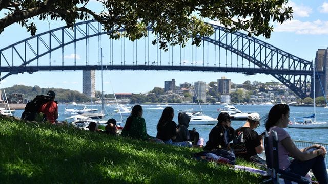 Vor den Silvesterfeierlichkeiten in Sydney versammelt sich eine kleine Menschenmenge an einem Aussichtspunkt mit Blick auf die Harbour Bridge. Vor den Silvesterfeierlichkeiten in Sydney versammelt sich eine kleine Menschenmenge an einem Aussichtspunkt mit Blick auf die Harbour Bridge.