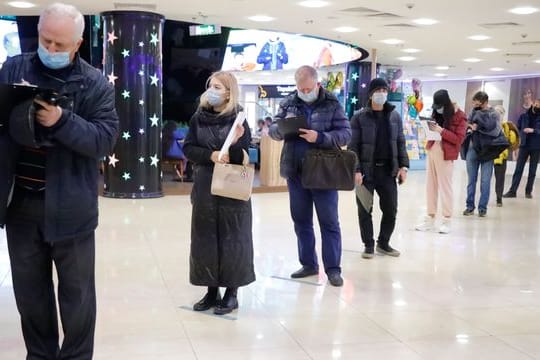 Menschen stehen in einem Einkaufszentrum in Moskau für eine Corona-Impfung an.