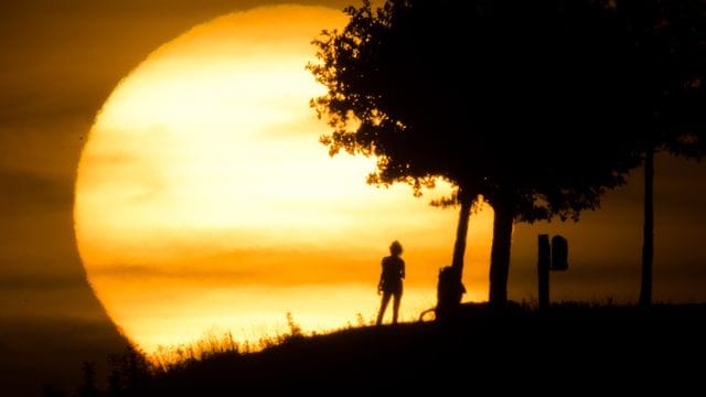 Passanten am Kronsberg in Hannover bei einem Sonnenuntergang.