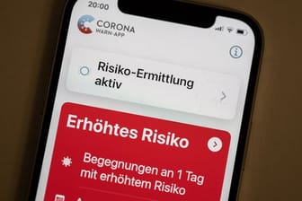 Eine Corona-Warn-App zeigt auf einem Handy ein erhöhtes Risiko an, mit einer an Corona infizierten Person Kontakt gehabt zu haben.