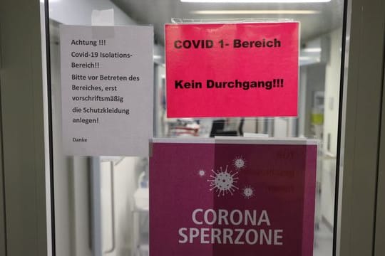 Hinweisschilder hängen am Eingang der Covid-19-Intensivstation einer Klinik in Gera.