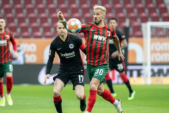 Augsburgs Niklas Dorsch (v) versucht, den Ball gegen Eintrachts Kapitän Sebastian Rode zu behaupten.
