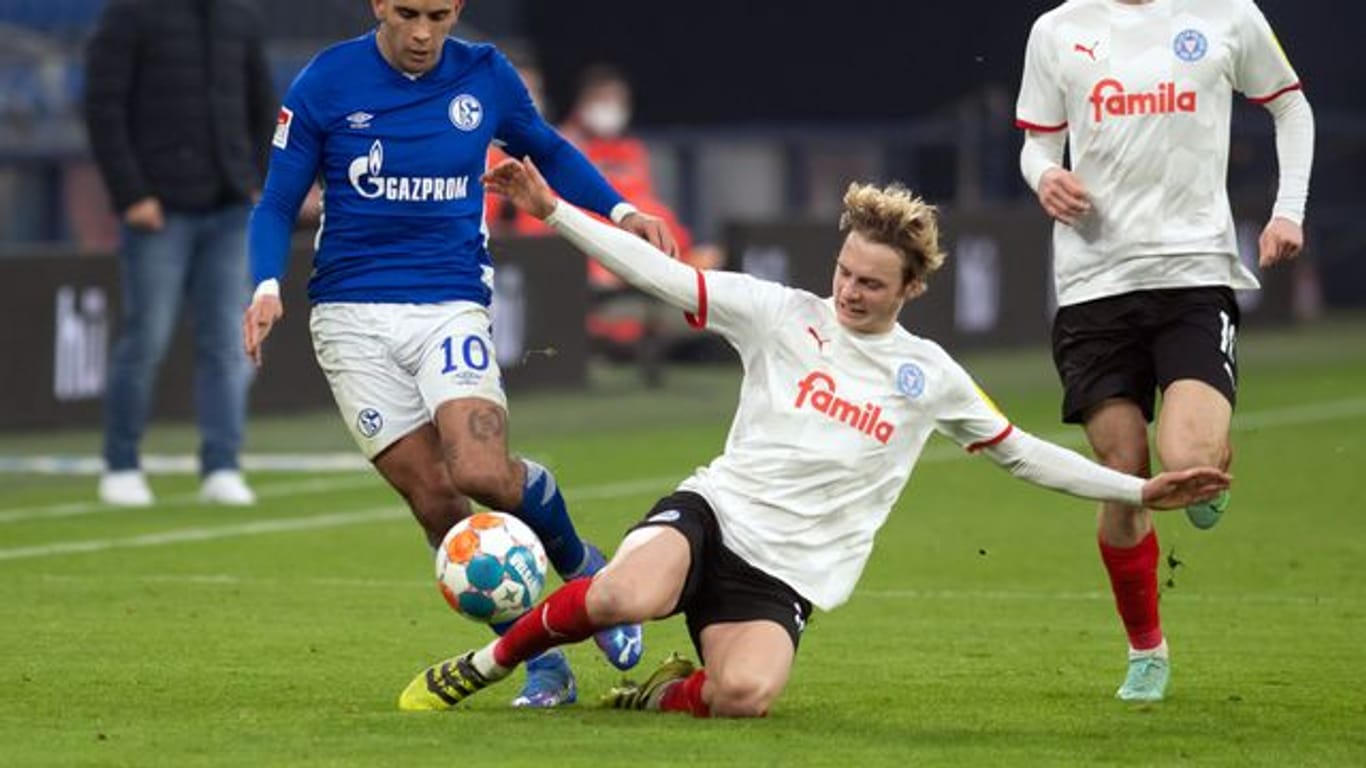 Kiels Finn Porath (M) geht in den Zweikampf mit Schalkes Rodrigo Zalazar (l) um den Ball.