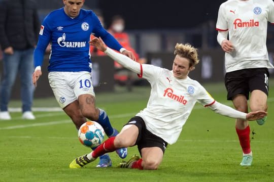 Kiels Finn Porath (M) geht in den Zweikampf mit Schalkes Rodrigo Zalazar (l) um den Ball.