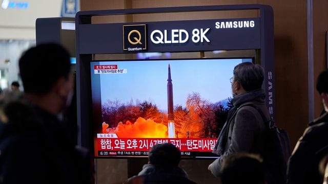 Menschen im Bahnhof von Seoul schauen auf Archivszenen eines nordkoreanischen Raketenstarts.