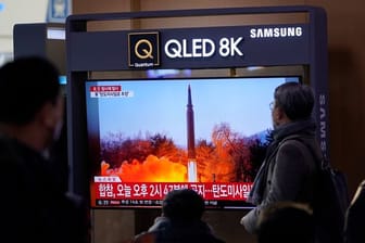Menschen im Bahnhof von Seoul schauen auf Archivszenen eines nordkoreanischen Raketenstarts.