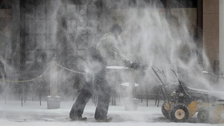 Ein Mann räumt Schnee auf dem Fußweg entlang der Fifth Street in Winston-Salem.