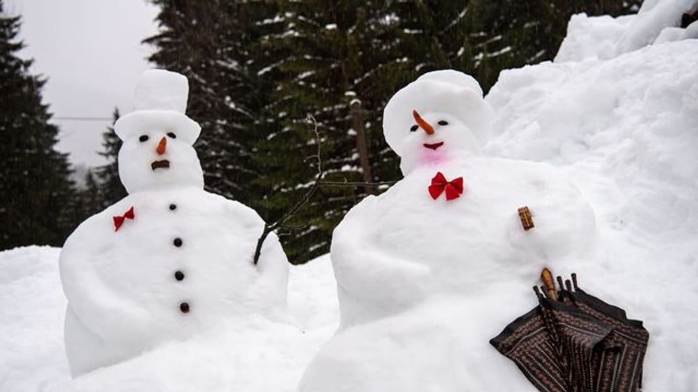 Vergänglich: Ein Schneemann und eine Schneefrau im Regen.