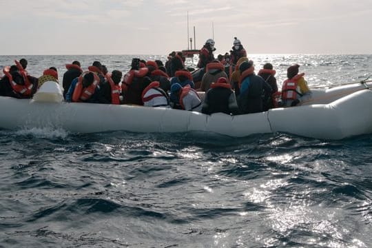 Menschen in einem in Not geratenen Boot auf dem Mittelmeer.