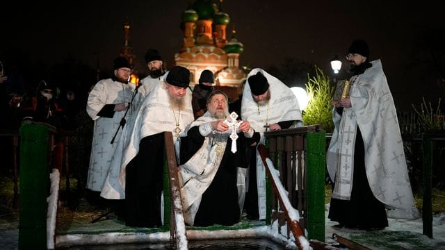 Ein russisch-orthodoxer Priester segnet am Dreikönigstag das eiskalte Wasser in der Kirche der Heiligen Dreifaltigkeit in Moskau. Ein russisch-orthodoxer Priester segnet am Dreikönigstag das eiskalte Wasser in der Kirche der Heiligen Dreifaltigkeit in Moskau.