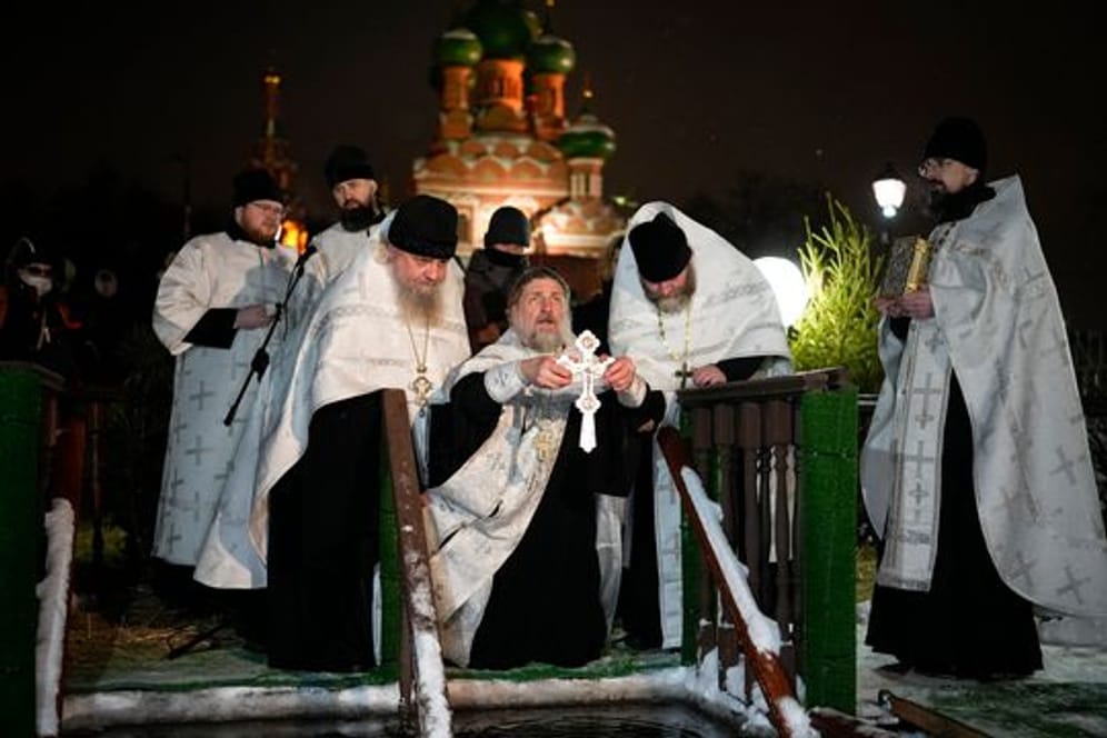 Ein russisch-orthodoxer Priester segnet am Dreikönigstag das eiskalte Wasser in der Kirche der Heiligen Dreifaltigkeit in Moskau.