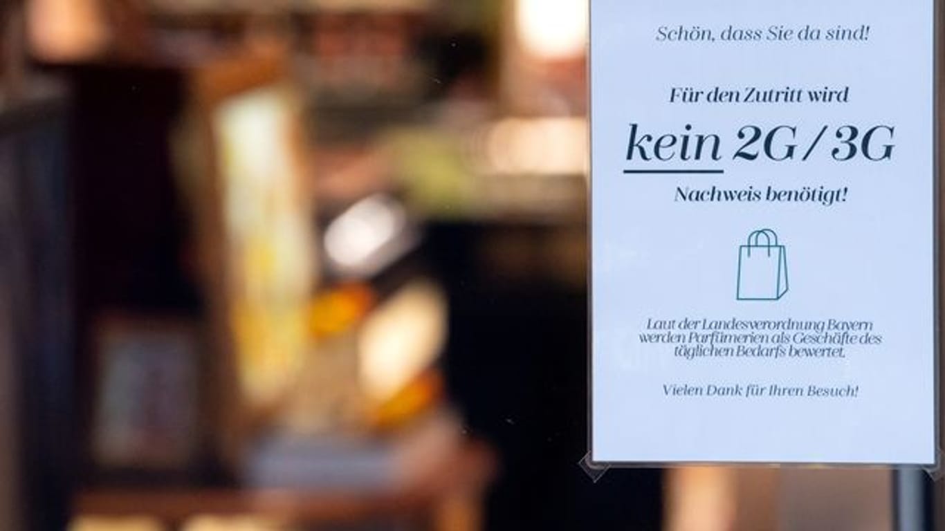 Ein Schild mit der Aufschrift "Für den Zutritt wird kein 2G/3G Nachweis benötigt" hängt im Schaufenster eines Münchner Geschäfts.