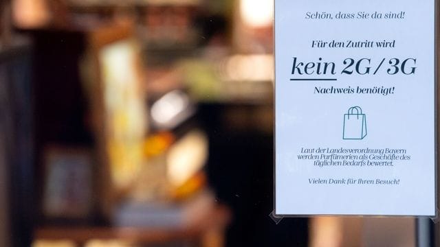 Ein Schild mit der Aufschrift "Für den Zutritt wird kein 2G/3G Nachweis benötigt" hängt im Schaufenster eines Münchner Geschäfts. Ein Schild mit der Aufschrift "Für den Zutritt wird kein 2G/3G Nachweis benötigt" hängt im Schaufenster eines Münchner Geschäfts.