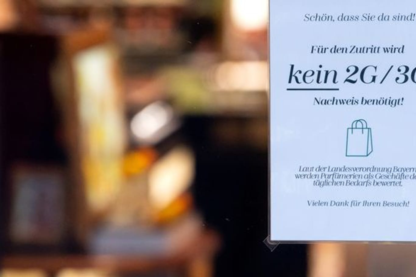 Ein Schild mit der Aufschrift "Für den Zutritt wird kein 2G/3G Nachweis benötigt" hängt im Schaufenster eines Münchner Geschäfts.