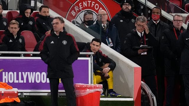 Manchester Uniteds Cristiano Ronaldo (M) verfolgt nach seiner Auswechslung durch Trainer Ralf Rangnick (v) das Spiel. Manchester Uniteds Cristiano Ronaldo (M) verfolgt nach seiner Auswechslung durch Trainer Ralf Rangnick (v) das Spiel.