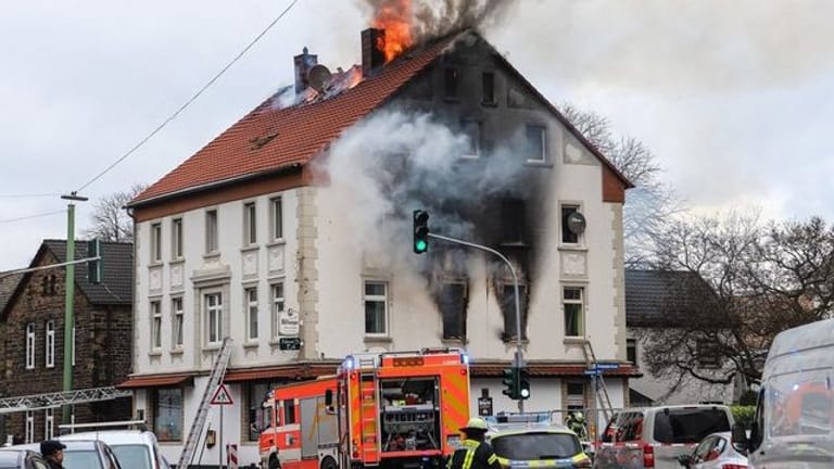 Einsatzkräfte der Feuerwehr bei dem Brand in dem Mehrfamilienhaus in Hagen.