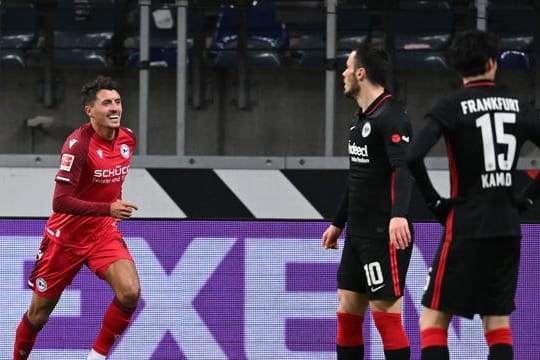 Bielefelds Alessandro Schöpf (l) feiert sein Tor zur 2:0-Führung neben den Frankfurtern Filip Kostic (M) und Daichi Kamada.