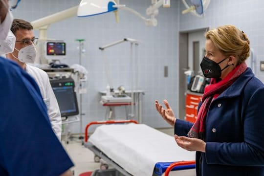 Berlins Regierende Bürgermeisterin Franziska Giffey (SPD, r) spricht mit Krankenhausmitarbeitern über die aktuelle Versorgungslage in Berlins Krankenhäusern.