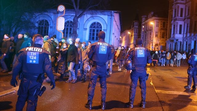 Teilnehmer einer Demonstration gegen die Corona-Maßnahmen gehen durch die Innenstadt von Gera und werden von der Polizei begleitet.