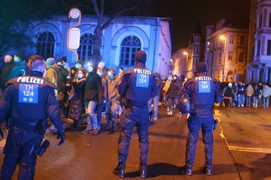 Teilnehmer einer Demonstration gegen die Corona-Maßnahmen gehen durch die Innenstadt von Gera und werden von der Polizei begleitet.