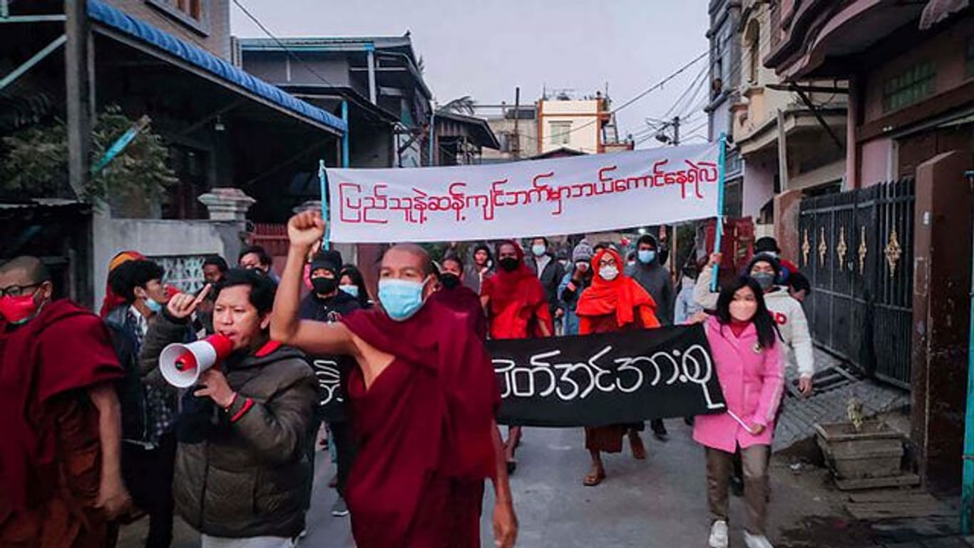 Junge Aktivisten und buddhistische Mönche bei einer Protestkundgebung gegen die Militärregierung in Mandalay.