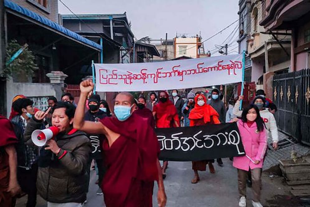 Junge Aktivisten und buddhistische Mönche bei einer Protestkundgebung gegen die Militärregierung in Mandalay.