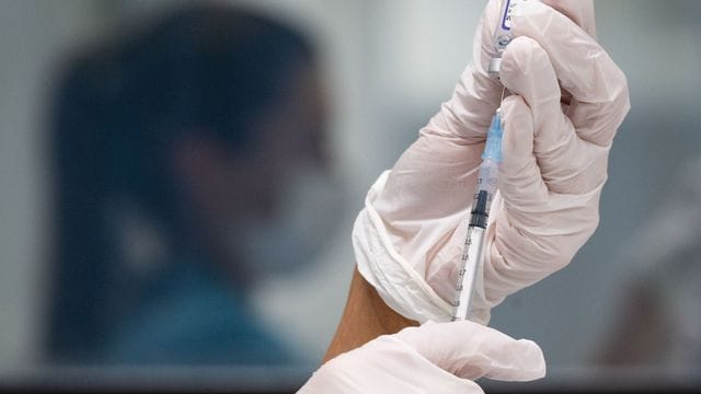 Eine medizinische Mitarbeiterin zieht in einem Impfzentrum eine Dosis des Impfstoffes von Biontech/Pfizer auf. Eine medizinische Mitarbeiterin zieht in einem Impfzentrum eine Dosis des Impfstoffes von Biontech/Pfizer auf.