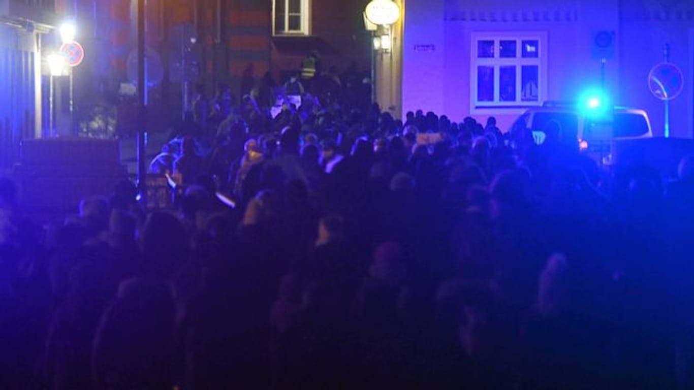Teilnehmer einer Demonstration gegen die Corona-Maßnahmen gehenn durch die Altstadt von Stralsund.
