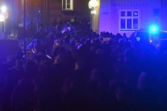 Teilnehmer einer Demonstration gegen die Corona-Maßnahmen gehenn durch die Altstadt von Stralsund.