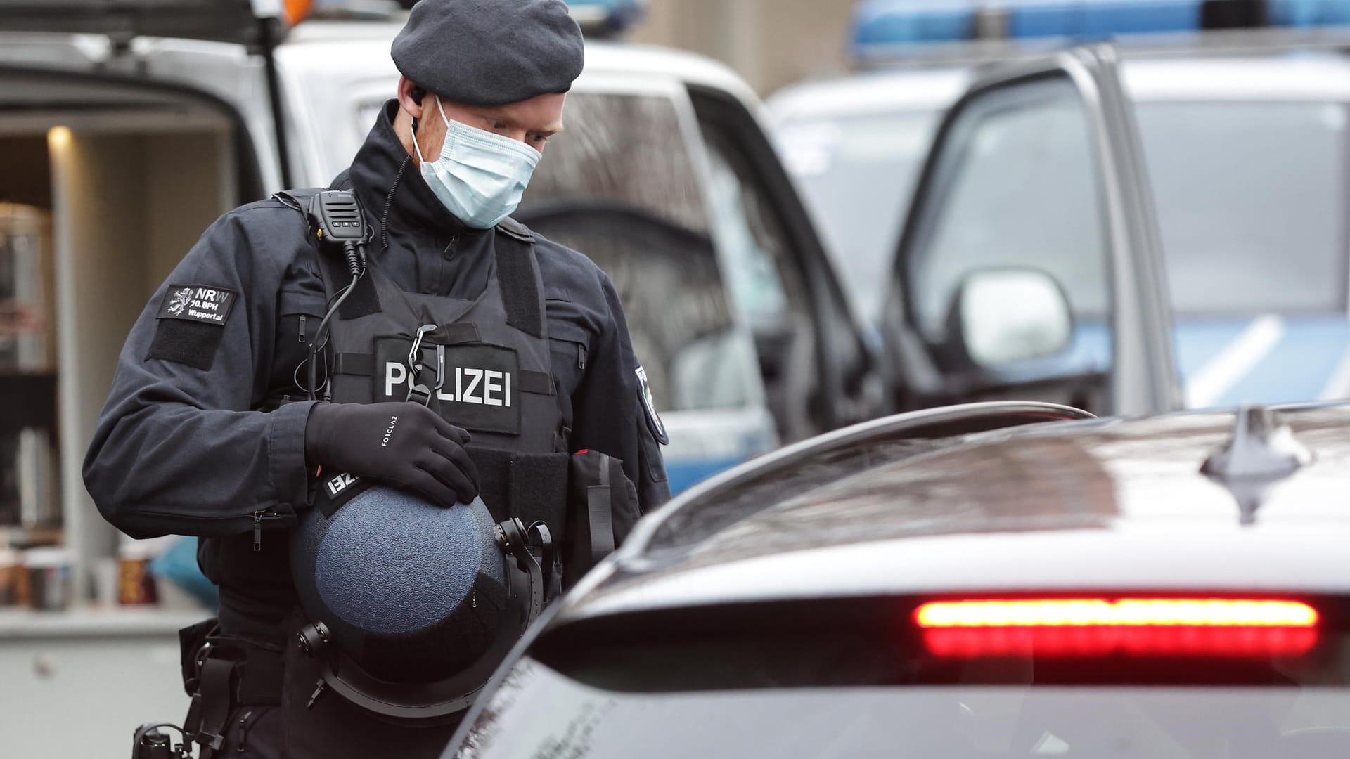 Polizeikräfte kontrollieren jedes Fahrzeug, das beim Landgericht geparkt werden soll: Eine Hundertschaft ist im Einsatz, um den Prozess abzusichern.